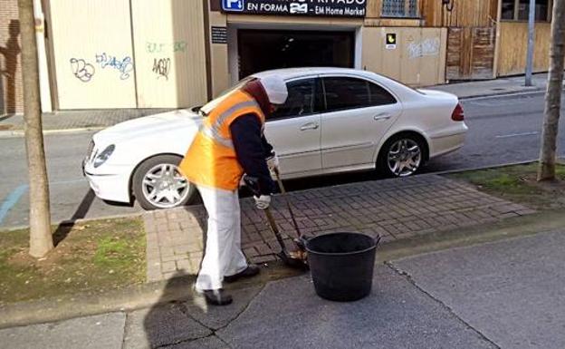 Un operario de limpieza barre una calle en Ponferrada.