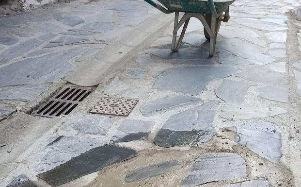 La Brigada de Obras de Ponferrada repara el firme de pizarra en la calle principal de la pedanía de Valdecañada