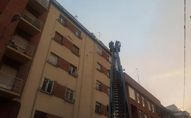 Los Bomberos cortan la calle López de Fenar para poder retirar placas de hielo de los tejados