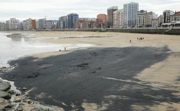 La playa de San Lorenzo de Gijón amanece cubierta de una mancha de carbón