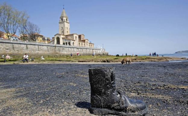 La playa de San Lorenzo de Gijón amanece cubierta de una mancha de carbón