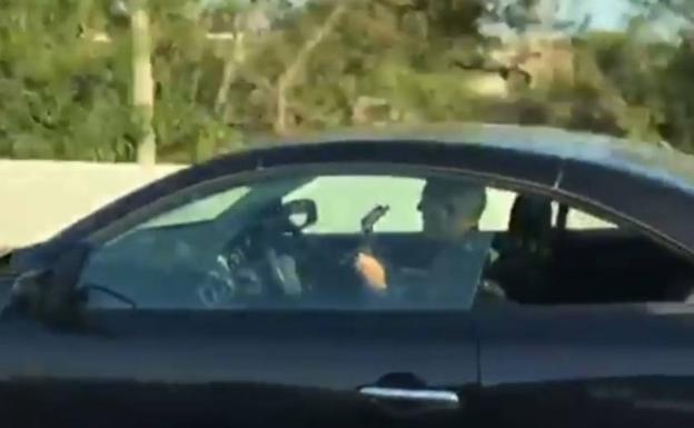 Graban a un conductor tocando la guitarra conduciendo sin tocar el volante