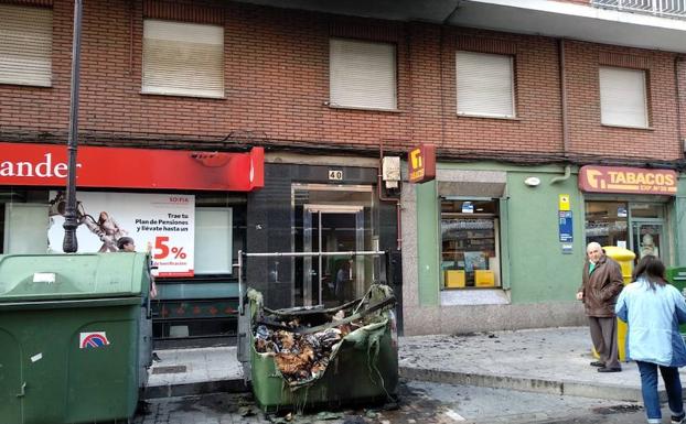 Las llamas de un contenedor ardiendo calcinan parte de una fachada en José María Fernández