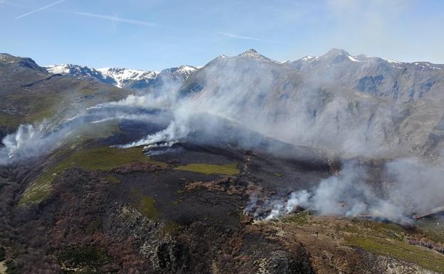 Medios aéreos y terrestres trabajan en la extinción de un incendio en los montes de La Baña