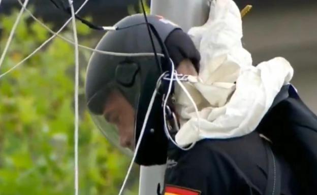 Un paracaidista se queda enganchado en una farola durante el desfile de las Fuerzas Armadas
