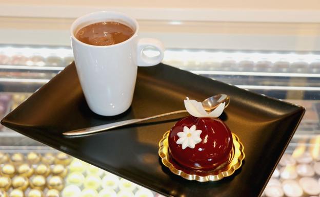 Un chocolate a la taza con un pastel de la confitería.