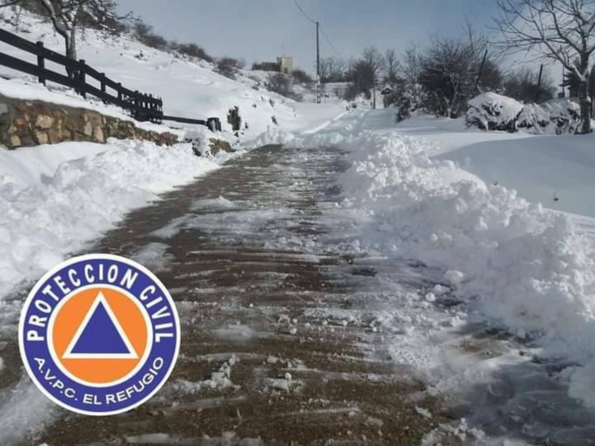 Los voluntarios de Protección Civil despejan la nieve caída los últimos días en Ferreras del Puerto