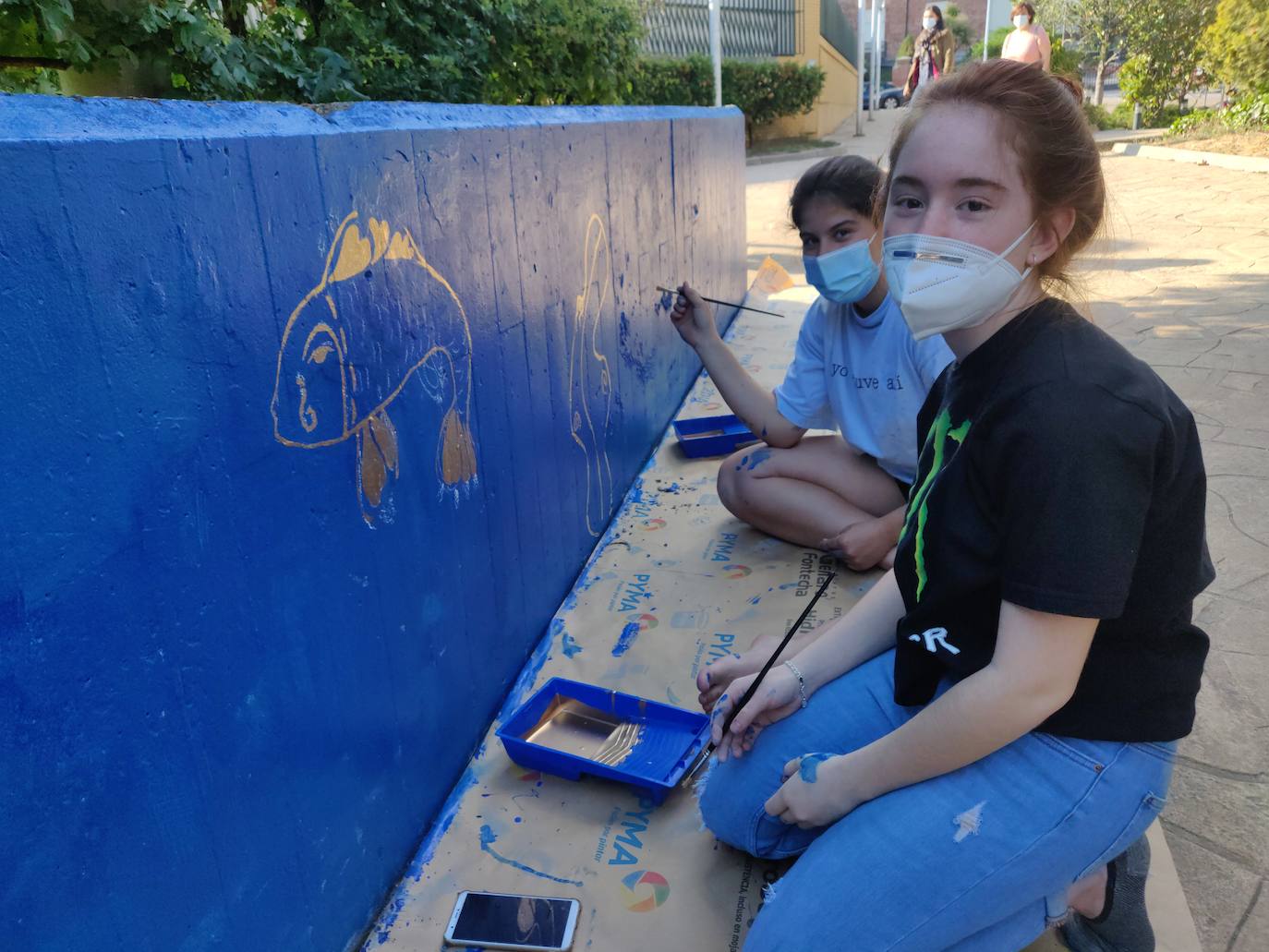 Varios alumnos adecentan un mural de la Calle las Fuentes en homenaje al pintor leonés Escanciano