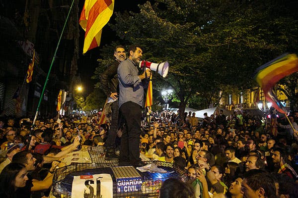 Cuixarte y Sànchez, sobre un vehículo de la Guardia Civil en el asedio de la Consejería de Economía de Cataluña. /EFE