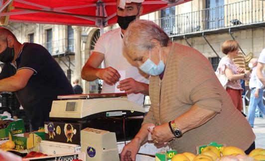 Visi coloca la fruta en el puesto del Mercado. /