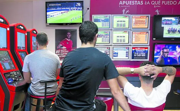 Enganchados. Jugadores siguen retransmisiones deportivas en una casa de apuestas./Isabel B. Permuy