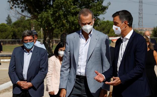 El rey Felipe VI y el presidente del Gobierno, Pedro Sánchez, conversan durante su visita este sábado al centro de acogida temporal instalado en la base de Torrejón./EFE