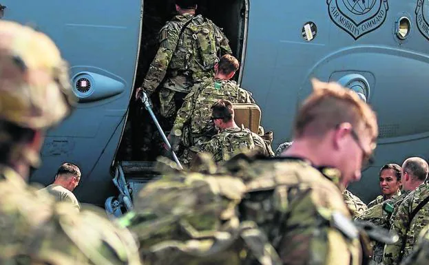 Soldados estadounidenses subiendo a un avión de transporte./