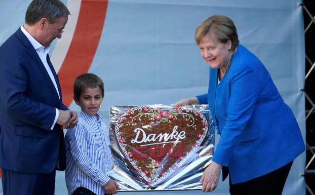 Merkel, con una tarta de agradecimiento de su partido./AFP