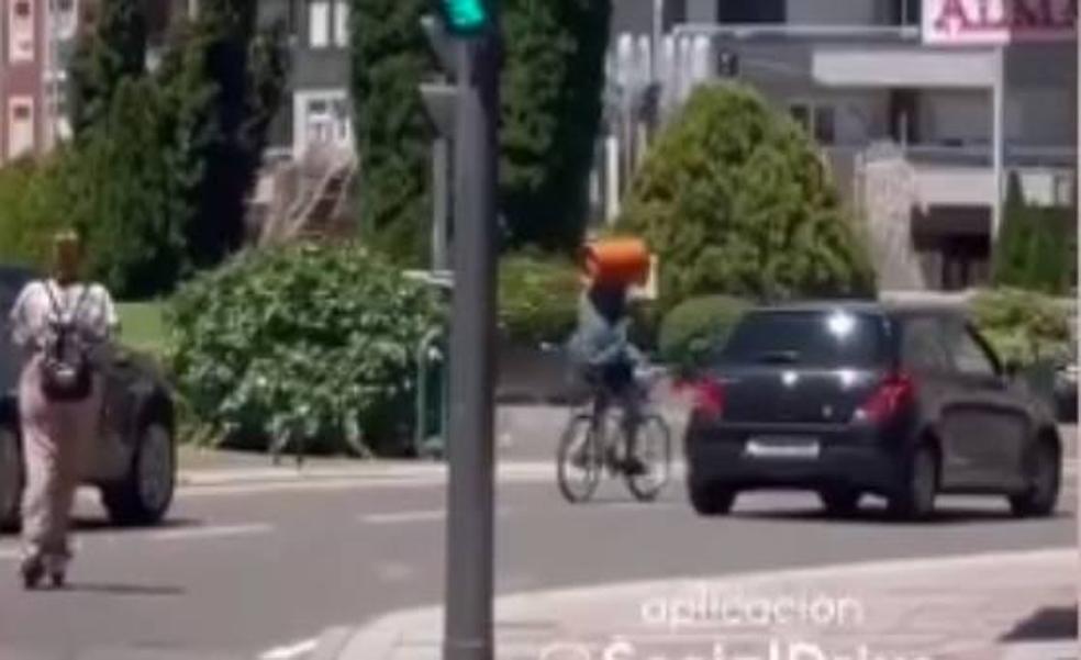 Rocambolesca imagen en León: un ciclista circula con una bombona de butano al hombro