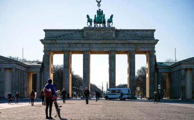 Viandantes junto a la Puerta de Brandeburgo, en Berlín. /