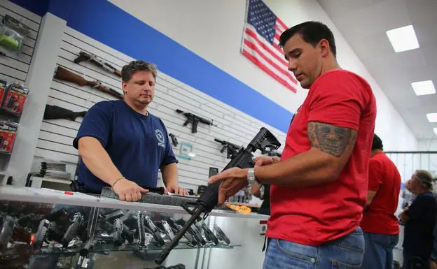 Un ciudadano observa detenidamente un arma en una armería de Florida. /AFP